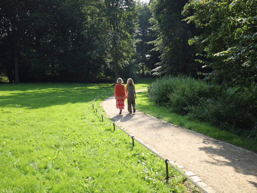 Petra Seidler und eine Frau gehen einen Weg entlang