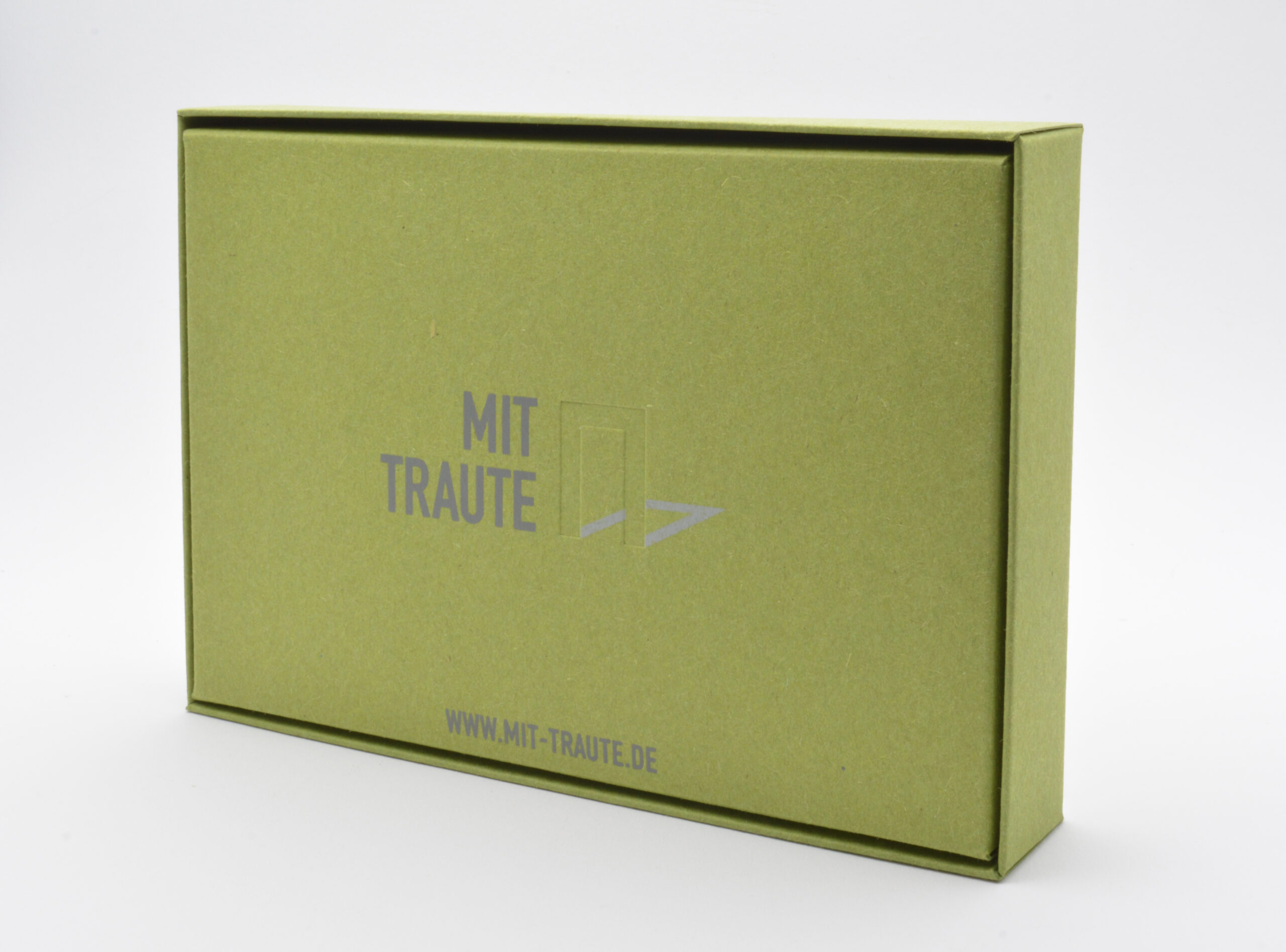 Geschlossene grüne TRAUDO®-Verpackung Rückseite mit "Mit Traute"-Prägung